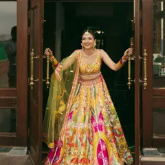 Celebrating love in shades of yellow! The bride makes a joyful entrance in her vibrant, multi-colored lehenga, ready for her Haldi ceremony.