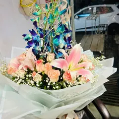 A premium hand-tied bouquet featuring vibrant blue orchids, soft pink lilies, and delicate peach roses. This is a great choice if you want a modern and elegant flower arrangement.