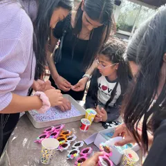 Party activities go beyond the paintbrush. Here, kids are having a blast decorating their own funky sunglasses, adding another layer of creative fun to the celebration.