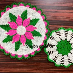 A pair of round crochet doilies, one large and one small, featuring a vibrant pink, green, and white floral pattern.