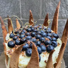 A close-up of the 'Doro' cake, showing the rich texture of the frosting and the abundance of fresh, juicy blueberries. All my fruit is sourced locally.