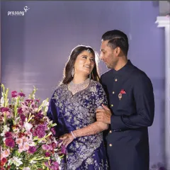 A candid moment of love and laughter during the reception. The bride's stunning navy blue lehenga complements the groom's classic attire, a perfect pairing for an elegant evening.