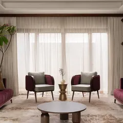 The formal living area of our 'Tinted Tapestries' project, where sofas in a deep plum hue are paired with sage green armchairs. The design showcases our ability to weave together a rich and cohesive color story across a single space.