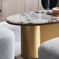 A close-up of the “Ananta” center table, showcasing the beauty of Patagonia Brazilian marble with its scenic, crystal-like patterns. The table is supported by a brass base shaped like an infinity symbol, representing timeless design and enduring quality.