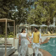 A stylish portrait of a couple walking by the pool in beautiful ethnic wear. This is a perfect example of a candid-style portrait that still feels elegant and well-composed.