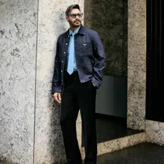A three-quarter shot against a marble wall, emphasizing the sharp, contemporary feel of the outfit.