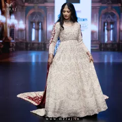 A full view of the showstopper tail gown on the runway, a masterpiece designed for the modern queen with its rich maroon Persian veil.