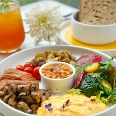 Our full English breakfast bowl, a complete and satisfying meal. It includes scrambled eggs, sausages, bacon, baked beans, sautéed mushrooms, and fresh greens, perfect for a hearty start to the day.