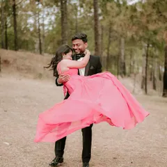 Capturing the playful side of your relationship. The groom lifts his bride-to-be in a sun-dappled forest, a perfect example of the fun, candid moments we'll create during your pre-wedding session.