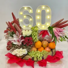 Celebrating a 60th anniversary with a hamper that's as fresh and vibrant as ever. This beautiful arrangement combines a basket of fresh fruits with lilies and roses, topped with a light-up "60" sign.