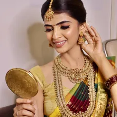 The final reveal is a moment of joy. Here, a model admires the completed South Indian bridal makeup, a testament to the skills and confidence our students build during the course.