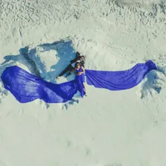 An aerial view shows the full effect of our royal blue trail gown. The expansive train creates a beautiful shape against the white sand, perfect for drone shots and epic couple portraits.