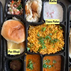 A popular combination for office lunches. This ready-to-eat meal tray includes flavorful Pav Bhaji, Tawa Pulao, Hara Bhara Kabab, Peanut Kachumber, and Raita, offering a complete and satisfying meal.