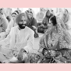 A quiet, shared glance between the bride and groom during their Anand Karaj ceremony. This black and white shot, framed by a soft pink border, highlights their connection amidst the sacred rituals.