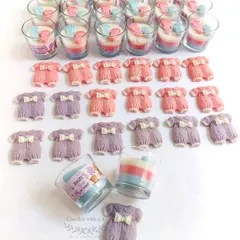 A collection of baby shower gifts ready for packing. This order included layered votive candles with baby feet and cute baby onesie soy wax sachets, showcasing the variety of items I can create for a single event.