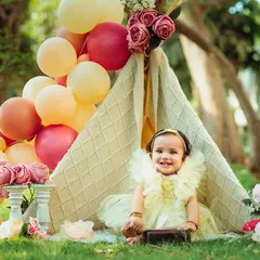 A wider view of the charming picnic setup. The natural light and green grass make the perfect backdrop for a first birthday.
