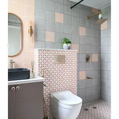 This bathroom renovation shows how color and pattern can completely transform a small space. I used a playful mix of pink and grey tiles, with a bold geometric pattern for the floor and accent wall. Sleek brass fixtures and a modern black sink provide a sophisticated contrast, creating a bathroom that is both fun and stylish.