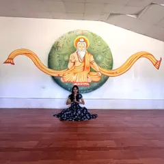 Posing with a completed mural of a rishi in a meditation hall. The goal was to create a serene and inspiring atmosphere, with symbolic elements from ancient scriptures integrated into the background.