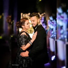 A classic and romantic reception portrait. The groom looks lovingly at his bride, and the soft lighting creates a beautiful, intimate atmosphere.