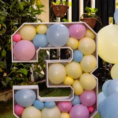 A large number '3' prop filled with pastel-colored balloons. This is a creative and eye-catching way to highlight the birthday age and serves as a great photo prop.