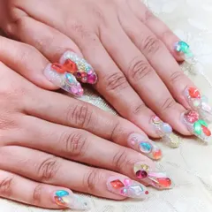For a truly glamorous look, I created these long gel extensions adorned with an elaborate arrangement of multi-colored rhinestones, gems, and 3D elements for maximum impact.