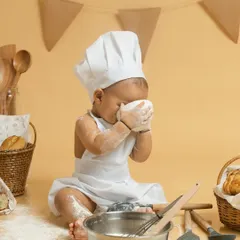 A candid moment of pure sensory play as this little chef gets a face full of flour. These unscripted, messy moments often make for the most memorable and joyful photographs.