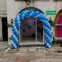 A classic balloon arch in corporate colors of blue and white, creating a welcoming entrance for an event at a clubhouse.
