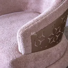 Detail of the Blush Haven Armchair's contemporary geometric motif. This close-up shows the intricate metalwork and the ultra-soft texture of the bouclé, a fusion of architectural grace and plush comfort.