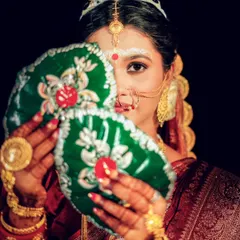 The iconic Shubho Drishti moment from a Bengali wedding. The bride's coy glance from behind the betel leaves is a beautiful tradition that I am always honored to capture.