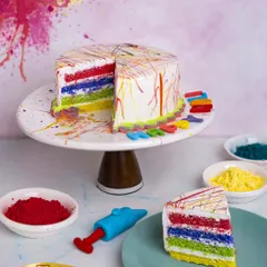 A surprise inside. This Holi-themed cake looks festive on the outside with its colorful splashes, but cutting into it reveals vibrant rainbow layers, making it a true celebration of color.
