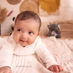 That heart-melting smile! A close-up of a happy baby during a family session in our boho set.