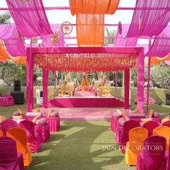 An explosion of color for an outdoor Mehndi. I used flowing drapes in shades of pink and orange to create a festive canopy, with a grand stage and comfortable floor seating for a relaxed, celebratory vibe.