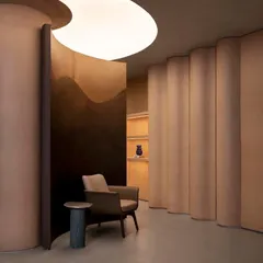 Curved partitions and carefully designed lighting create intimate nooks and moments of discovery within the open-plan showroom.