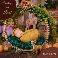 Welcome to the jungle! This enchanting woodland theme features a newborn sleeping in a rustic wreath, surrounded by greenery and adorable animal figures like a giraffe and a deer.