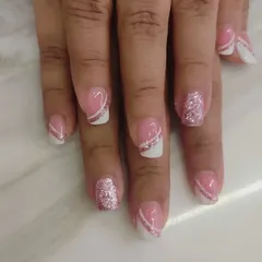 A modern and graphic take on the French manicure. I used a pink base with a white tip, separated by a diagonal silver glitter line for a sharp look.