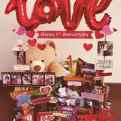 A classic first anniversary hamper that's all about love. It features a large teddy bear, a 'LOVE' balloon, photo film strips, and a huge assortment of chocolates and snacks to celebrate the milestone.