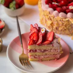 A beautiful slice of our Fresh Strawberry Cake, layered with light sponge and strawberry cream, topped with fresh sliced strawberries. This cake is the essence of winter, available only when the berries are at their best.