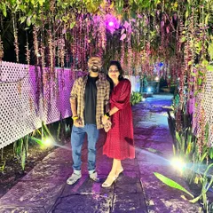 A couple cherishes a moment under a beautifully lit floral archway at our Ramanagara resort, a perfect spot for a romantic photo.