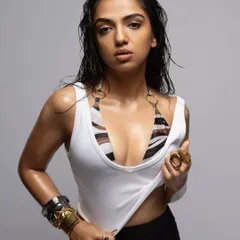 Another look from the same shoot, this time with a wet hair look for an edgier vibe. The styling combines a simple white tank top over a bikini top with statement hand jewelry.