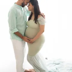 Soft light, sweet smiles, and the beginning of a new journey together. This light and airy couple's portrait, styled in gentle pastels, captures the serene happiness of expecting.