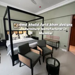 A full view of a hotel room I furnished, which includes a modern canopy bed, two caned lounge chairs, and a matching side table. This shows a complete, ready-to-book room solution.