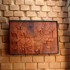 A framed terracotta tile mural depicting lotus flowers, hung against a textured brick wall. This piece highlights how we collaborate with artists to create custom works that complement the building's material palette.