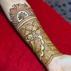 The beginning of a beautiful arm band. This photo shows the step-by-step process, starting with the main lotus motif and building the surrounding patterns.