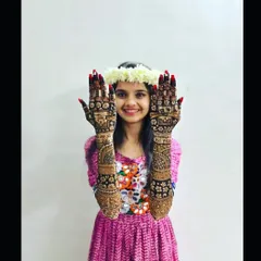 A beautiful, smiling bride showing off her full bridal mehndi. Her joy is the ultimate reward for my art.