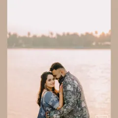 A romantic portrait set against the soft light of sunset by the water. This image from a Sangeet shoot captures a quiet, intimate moment amidst the celebration.
