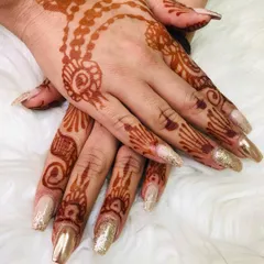 This design combines a soft, neutral base with gold chrome and glitter accent nails. It’s a perfect match for traditional bridal wear and henna.