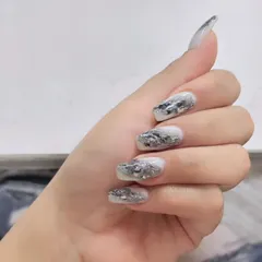 A modern and edgy design featuring a white base with a shattered silver foil effect, creating a textured, metallic look.