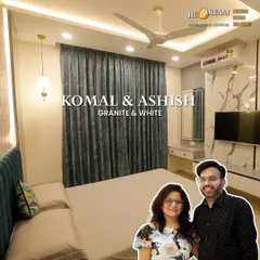 We created this serene bedroom for Komal and Ashish using a granite and white color palette. The design includes a floor-to-ceiling wardrobe, a dedicated vanity space, and a TV unit, all seamlessly integrated.