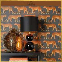 The 'Leopard Walk' wallpaper from Cole & Son adds a touch of the wild to this sophisticated space. The repeating pattern brings a rhythmic energy, creating a design that is both playful and elegant.