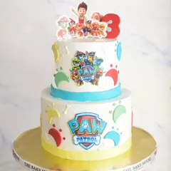 A fun two-tiered Paw Patrol cake for a third birthday. This cake uses edible prints of the characters and colorful paw prints to bring the theme to life with minimal fondant.